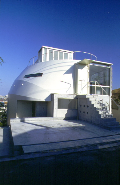 3 in 1 House This building consists of three independent residential units. It is designed carefully considering the privacy as well as the ecological aspect while benefitting the respective client economically. <br />This house is located in a residential area between Osaka and Kobe. The plot is situated approximately 3 meters below the street level. Therefore, the entrances to all units are located on the first floor. Each unit is approximately 80-90m2 and they are combined sterically in the way that one cannot recognize the boundaries among them from outside.<br />Two family units occupy two floors (ground floor and first floor) while each unit is provided with private yards. The penthouse unit enjoys a private roof deck instead. The numbers of the internal walls are kept to the minimum hence flexibility of the internal layout is increased. The southeast façade is fully glazed and enjoys the clear view of the city. Public areas of each residence are also located on the southeast side in order to maximize the benefit. In contrast, northwest façade is enclosed by the steel sheet that wraps three units altogether to maintain the privacy of each unit. The shape of this steel shelter is determined according to the analysis made with shadow plot, in order to avoid casting shadow on the adjacent land on the north side.<br />This building was planned before the great Hanshin earthquake and was in the middle of construction when it happened. Fortunately, there was no damage caused to the building structure. <br />Looking down from this house, the city seems to have recovered greatly over the past years, sadly the buildings built after the earthquake was mostly prefabricated and uncharacteristic. I’m just overwhelmed by the speed that they built. There are still fragments of small plots that have no beneficial use. To make matters worse, there seems to be no improvement of living environments. I hope that the idea of this small co-housing project can become one of the solutions to this problem.<br />(Award of excellence at Healthy Homes Contest)