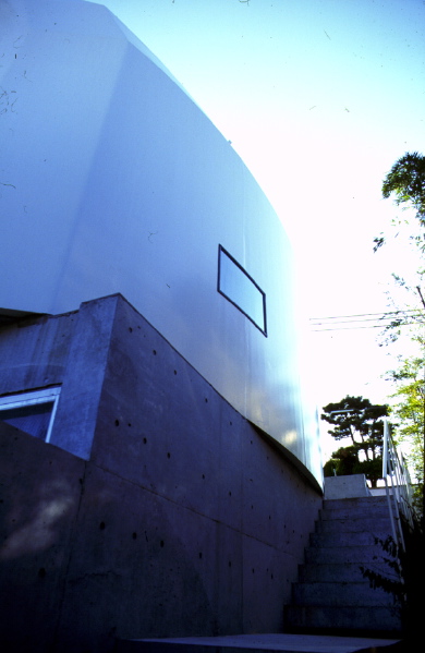 3 in 1 House This building consists of three independent residential units. It is designed carefully considering the privacy as well as the ecological aspect while benefitting the respective client economically. <br />This house is located in a residential area between Osaka and Kobe. The plot is situated approximately 3 meters below the street level. Therefore, the entrances to all units are located on the first floor. Each unit is approximately 80-90m2 and they are combined sterically in the way that one cannot recognize the boundaries among them from outside.<br />Two family units occupy two floors (ground floor and first floor) while each unit is provided with private yards. The penthouse unit enjoys a private roof deck instead. The numbers of the internal walls are kept to the minimum hence flexibility of the internal layout is increased. The southeast façade is fully glazed and enjoys the clear view of the city. Public areas of each residence are also located on the southeast side in order to maximize the benefit. In contrast, northwest façade is enclosed by the steel sheet that wraps three units altogether to maintain the privacy of each unit. The shape of this steel shelter is determined according to the analysis made with shadow plot, in order to avoid casting shadow on the adjacent land on the north side.<br />This building was planned before the great Hanshin earthquake and was in the middle of construction when it happened. Fortunately, there was no damage caused to the building structure. <br />Looking down from this house, the city seems to have recovered greatly over the past years, sadly the buildings built after the earthquake was mostly prefabricated and uncharacteristic. I’m just overwhelmed by the speed that they built. There are still fragments of small plots that have no beneficial use. To make matters worse, there seems to be no improvement of living environments. I hope that the idea of this small co-housing project can become one of the solutions to this problem.<br />(Award of excellence at Healthy Homes Contest)