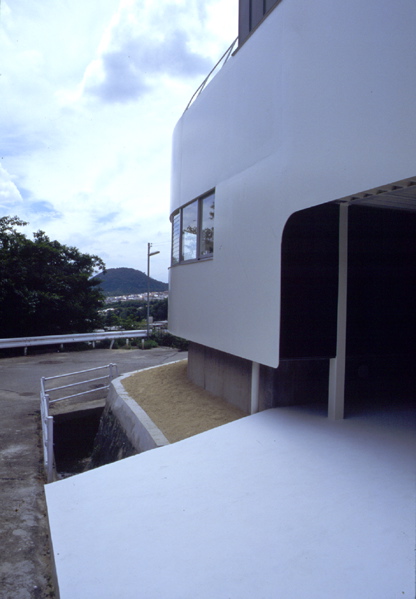 1/4 Circle House TThe project site is set on a slope with privileged view of Rokko-mountain and Osaka-bay. 9mm steel sheet with 20m in length takes the shape of a quarter circle with a radius of 6m, and the continuous wide window provides a panoramic view. This column-less continuous window was achieved by freeing the wall from the structure. <br />The entrance hall and the courtyard are paved using the same material, enhancing the spatial continuity of the space. The panoramic view is available not only from the indoor space but also from the courtyard. The courtyard is located at the center of the building so that circulation flows round the void. It also works as environmental device, which maintains the natural lighting and the ventilation. <br />This house accommodates a young married couple with a parent. They can share the panoramic view from the common living room and the kitchen, while the courtyard keeps them apart efficiently where privacy is required.<br />I intended to maintain the privacy and utility while trying to enhance the relationship between human and natural environment, which is an eternal task of urban living. <br />