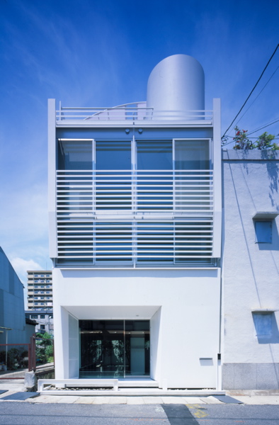 Mo House This house is situated in relatively high-density urban context consisting mixed residential/commercial use. It sits on a narrow site measuring approximately 59m2. The shop on the ground floor is visually connected to the courtyard at the rear. The residential part is situated on the upper floor. <br />I have taken in account the geographic feature of Kobe when designing this house. North and South façades are double-glazed, providing the views of mountain and sea. These openings and the courtyard efficiently provide the natural lighting and the ventilation into the internal space. Private areas are placed on the first floor and the living room is located on the second floor. The layout is carefully considered so that spatial volume and the brightness increase as one proceeds to the higher floor. The roof top terrace comprises sanitary space and it acts as the sky garden that offers the view of sky, mountain and sea.<br />The reason I’m attracted to steel as building material is for its unlimited possibilities. I’m convinced that it goes beyond the structural limitation that has been established during the modernist age. In addition to its structural durability, I also consider steel as a high quality external cladding material.<br />I chose to use 9mm steel sheet not only for its texture and durability but also for the impression it can give of being thin. I believe the texture of steel, like the texture of thick stone in Mies’s architecture, can create the impression of reliability and sophistication.<br />For instance, a car needs to be light and durable, but texture of thin steel sheet wrapped around it is never considered as important as it is in architecture. The application of steel in architecture is not only about the manufacturing process in factory. The thinness of the material changes according to the size of the space and it will affect the impression and the texture. The reason I’m being particular about the texture is because architecture is not merely used, but also is lived in.<br />