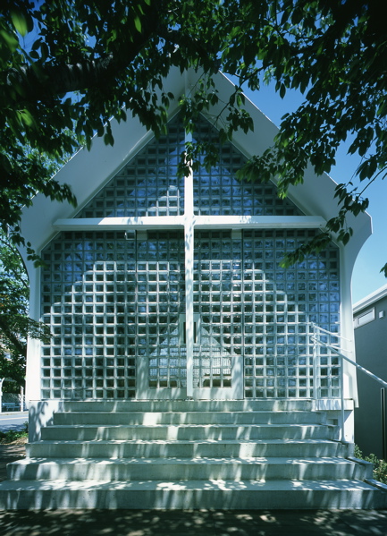 Kobe Shinsei Baptist Church Personally, I often like to pay visits to churches when I travel. As the symbol of a city, as the fruits of history and human activities, they stand with an unspoken appeal to people’s heart. When one feels the touches of the bear cold stone, or the tension of silence, he learns sacredness and dignity of life. <br />Kobe Shinsei Baptists Church used to be a small chapel attached to the clergy’s house. It later was put on sale due to the withdrawal of religious organization whose headquarter was located in the US. The remaining groups of Baptists were left with no other choice but to re-establish the church. They organized several workshops with supporters and student volunteers to elaborate their plans for raising fund and realizing the project that started from scratch. <br />Kobe Shinsei Baptists Church comprises a chapel, in addition to offices and a meeting hall on the lower floor. The church was constructed under the direct management due to serious budget constraints. I have tried to explore ways to realize an exposed-structure architectural design, by simplifying the constituent members and eliminating the finishing materials. <br />The chapel is composed of a steel monocoque structure. It is a technique that uses building’s external skin to support the structure. <br />I designed the roof with an open slit on top, and openings between the concrete inverted beams and the steel sheet wall, to allow natural stack ventilation. It is a sustainable form of architecture whose structure and functionality are inseparable. <br />High-purity Italian glass blocks are installed in gable side façades. They are considered as independent structural element that transmit light into the building. The main entrance is integrated in the glass block wall. <br />The meeting hall has a vaulted exposed concrete ceiling that takes full advantage of the plasticity of concrete.<br />In the end, both steel and glass are originally minerals. Although we are living in an affluent society, I believe design of churches should be humble and primitive. It should rely on daylight and candlelight instead of artificial light. This way, Silent, cold and sacred atmosphere of the space could be emphasized.<br /><br />Hiroaki KIMURA<br />