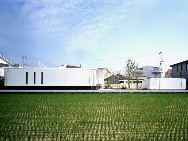 Float House This project site was originally two separate cultivation land of 330m2 and 198m2 that were later developed for housing lots. I have planned the housing part on one side and the garage part on the other. Consequently, I have succeeded in designing a rural house where modernity and tradition coexist.<br />This area has suffered from tsunami in the past, and it was predicted that it might happen again in the near future. Therefore, I have decided to lift the building (housing part) composed of steel sheet above the ground level. As a result, the design of the building has come out looking like a floating vehicle.<br />The semi-public area in this house comprises a doma entrance (entrance area situated at the same level as the ground), drawing room and guest room with exposed structural steel sheet finishing. The area intended for family use; Living room, dining room and bedrooms, are painted in white. Bathroom and kitchen are located along a passage with wood finishing. The passage takes light and air from triangular clearstory windows. As one walks through the house, three spaces with contrastive characteristics appear sequentially.<br />The house consists of two parts: the floating residential part and the garage part wrapped in steel sheet. They are located around a patio and fulfilling an open space that’s slightly isolated from the surroundings.<br />