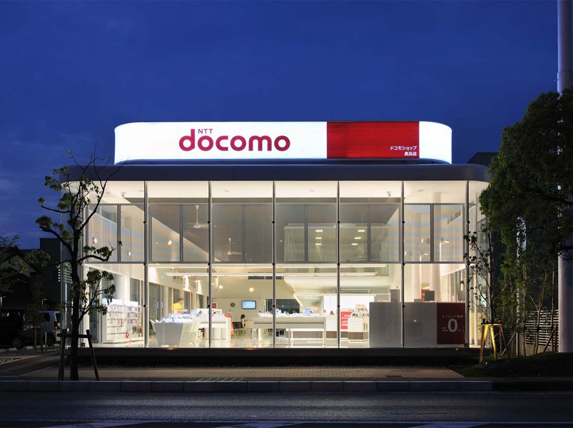 Docomo Shop Hikone This DoCoMo shop is a relatively large independent store located in rural area specialized in mobile phones. I would say it is quite a rare case.<br />The store comprises an ample waiting space, counter area, and offices at the rear. There is also one large, and one small meeting space on the first floor. This shop is open to the community and provides comfortable meeting space for local users. It assists making connections within local community.<br />This building is composed of two large volumes placed on top of each other. I tried to design an attractive space that wouldn’t appear too vacant or monotonic. The design of this building is an abstract forest with dynamic and elegant look. The beauty of this project is the harmony of aesthetic and structure.<br /><br />Hiroaki KIMURA <br /><br />Engineer’s comment<br />The architecture of DoCoMo shop gives off a new and innovative impression. The most characteristic features are the bristling thin columns that create an ample and comfortable space. The columns had to be thin, and no bracing or load bearing walls could be used because it was designed as a waiting space. Thus, we decided to use rigid frame structure for the office area so that columns in the waiting area could carry just the vertical load and the snow load. As a result, we were able to reduce the size of steel pipes to ϕ 114.3 and achieve the “abstract forest”. The roof trusses are connected by rigid joints so that they could transmit the seismic shear force from the meeting area roof to the structural members of office area. The house-shaped bent tuber pipe by itself is so weak that it has very small resistance to the vertical load. Therefore, we have placed thick diaphragms to reinforce the frame. The diaphragms can also prevent the frame to spread out when resisting vertical load. We have made an additional analysis of three-dimensional frame buckling to maintain the structural safety of this very thin structure.<br /><br />Iori KANEO (Morisako/Kaneo laboratory, Kyoto Institute of Technology)<br />