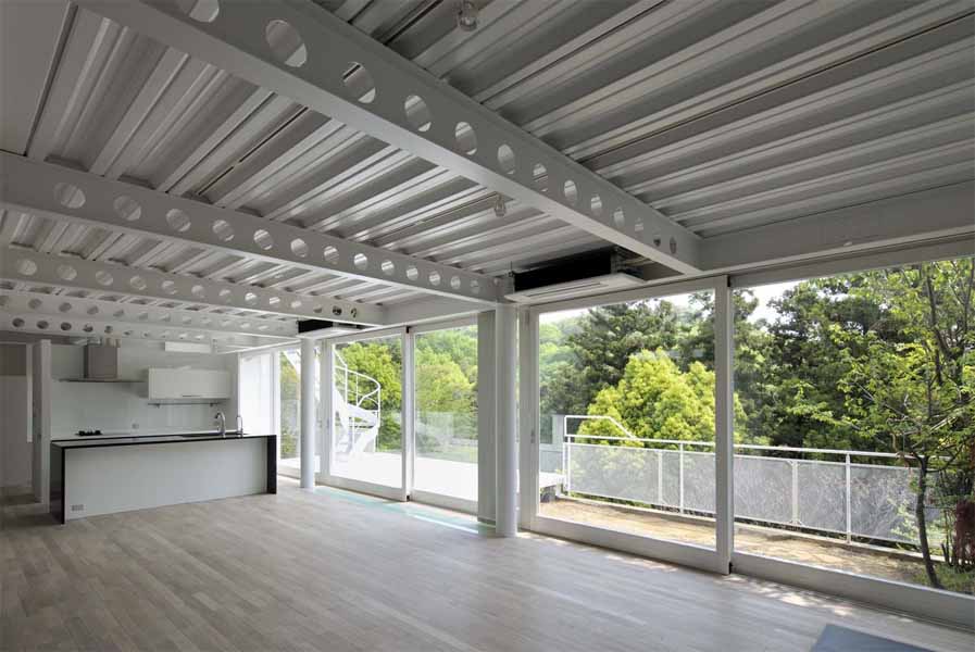 Open Terrace The main characteristics of this house are the deck terraces that open towards the forest. All three floors have large openings and terraces facing the forest on the east side. The overhang on the first floor is made of wooden louvers and glass so that light can reach the lower terrace. In contrast, the entrance hall and “doma” space (space situated at the same level as the ground) on the west side have only few small openings or lattice-windows to keep that part enclosed. This house is a harmonization between openness and calmness. 